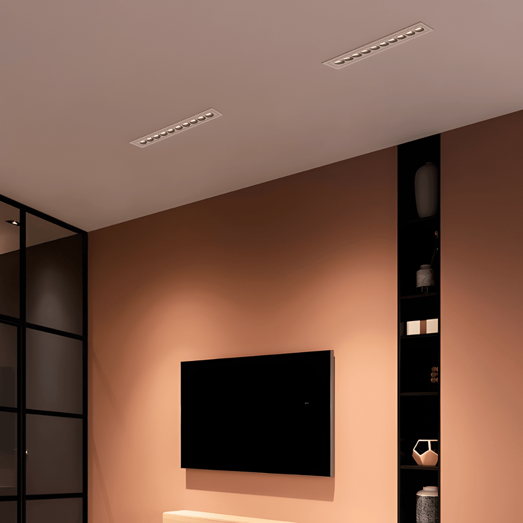 Clérachic two white recessed linear downlights with small reflectors, in a terracotta-toned living room ceiling above a wall-mounted TV.