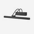 Black version of this Clérachic wall light, with its long round tube, curved double arm and boxy backplate, on a pale backdrop.
