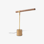 Three-quarter view of this Clérachic lamp on a white backdrop, with the walnut bar tilted up and the cord running left.