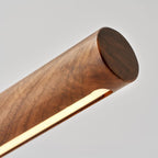Close view of the rounded walnut end and the glowing light strip along the underside of this Clérachic lamp.