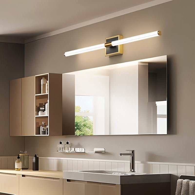 Clérachic LED tube wall light on a square brass plate, angled above a wide bathroom mirror and vanity with a mixer tap.