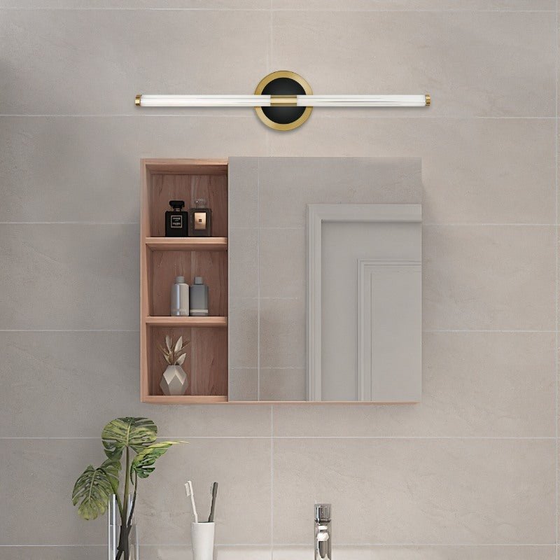 Clérachic LED tube wall light above a bathroom cabinet with open shelves, on a round black plate with a brass rim.