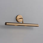 Close view of this Clérachic wall sconce on a grey wall, showing the aged bronze tube, round backplate and curved arm.