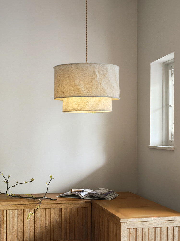 Tucked above a built-in wood bench with a trailing branch, this Clérachic pendant glows in a quiet corner.