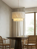 Beside sheer curtains and a round dining table with rattan chairs, this Clérachic pendant casts a warm glow.