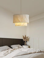 Above a dark upholstered headboard and pampas grass, this Clérachic pendant lights a neutral bedroom.