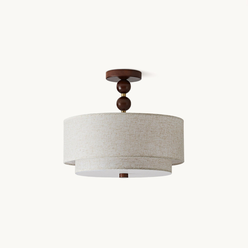 Clérachic double-cylinder flush-mount light with a linen shade and a walnut canopy and stem of two wooden balls, on a plain white backdrop.