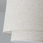 Close view of the loose, flecked linen weave on the two stacked shades of this Clérachic ceiling light.