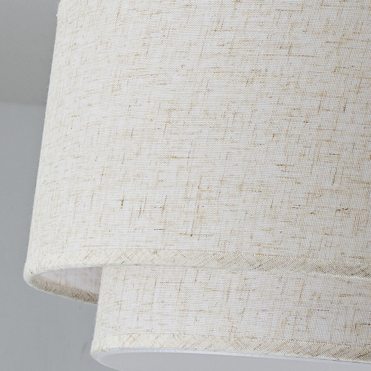 Close view of the loose, flecked linen weave on the two stacked shades of this Clérachic ceiling light.