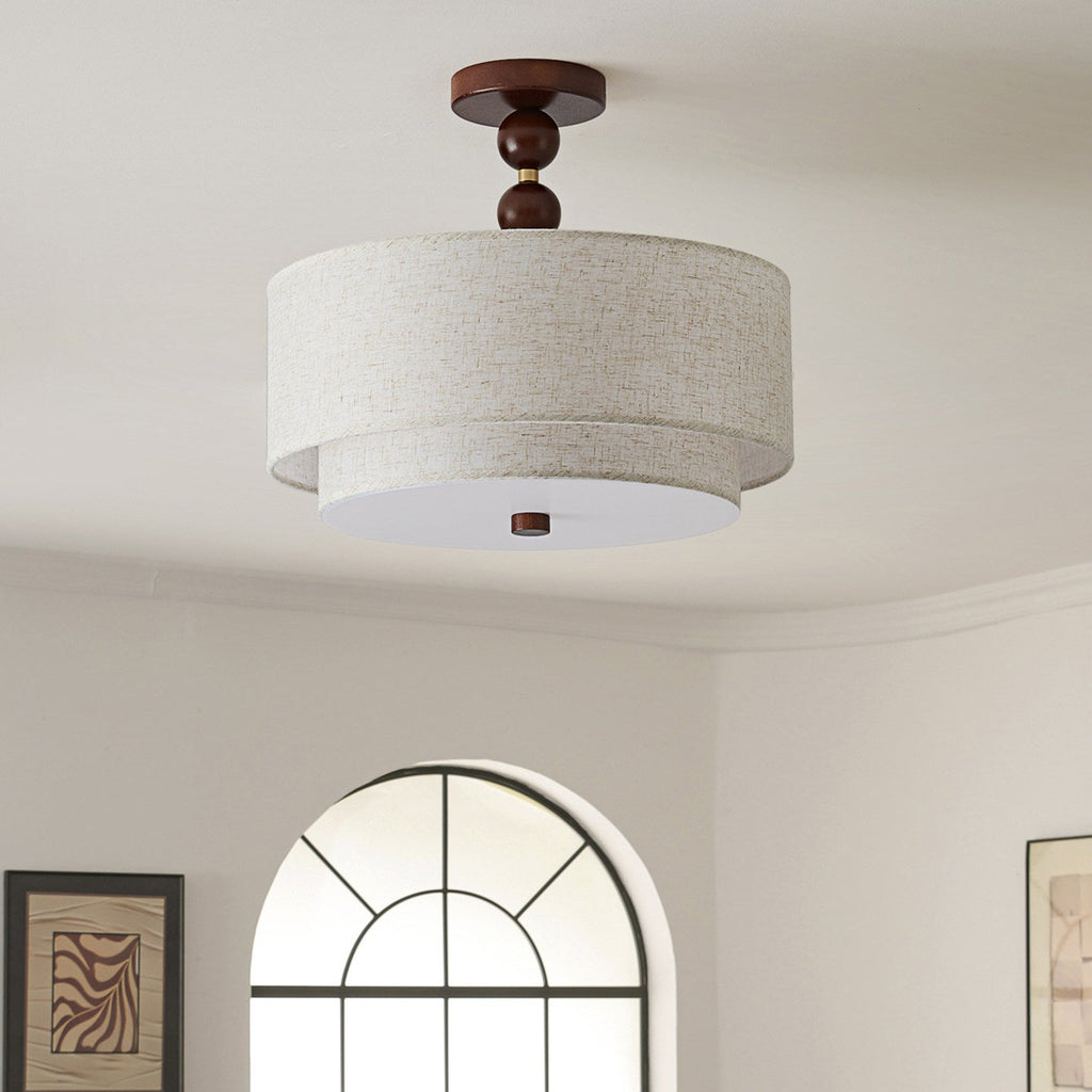 Clérachic walnut and linen ceiling light, unlit, against a pale grey wall with a framed print and a tall arched window.