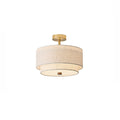 Clérachic gold and linen double-drum light with a brass canopy and stem, lit and shown on a plain white backdrop.