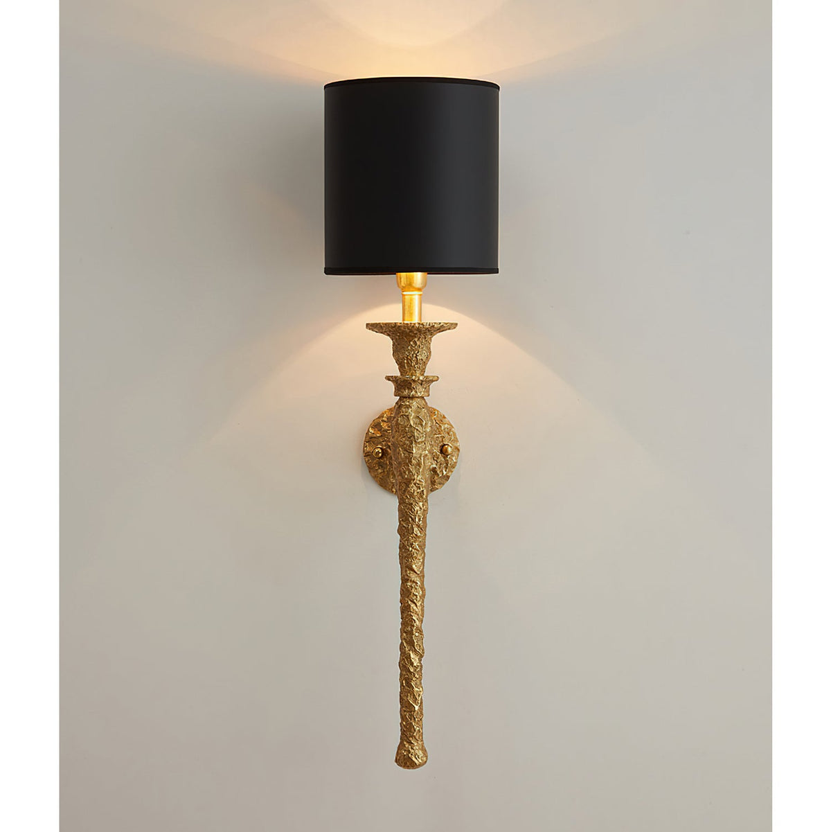 Straight-on view of the black-shaded Clérachic wall light, with warm light spilling from the open top and bottom of the shade.