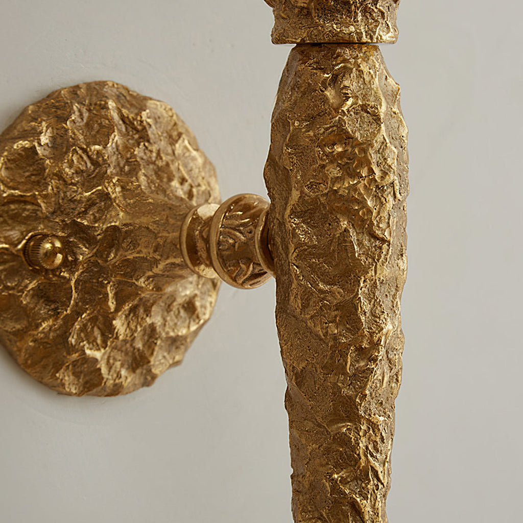 Close view of the hammered brass stem meeting the wall plate on this Clérachic wall light.