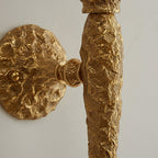 Close view of the hammered brass stem meeting the wall plate on this Clérachic wall light.