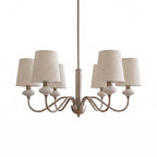 Six-light Clérachic chandelier in sand nickel with linen shades and white ceramic necks, on a white background.