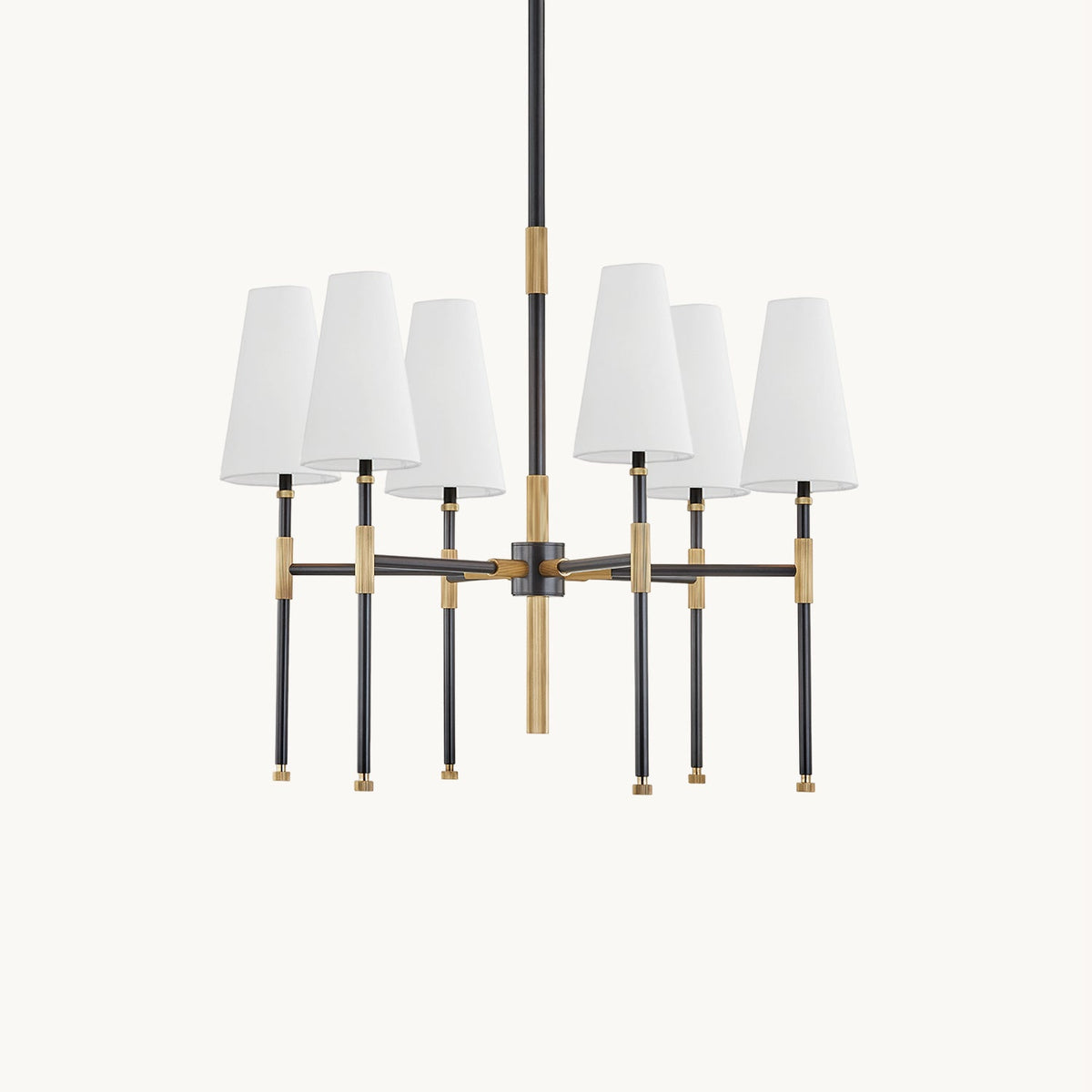This Clérachic six-light chandelier on a plain off-white backdrop, with six white linen shades on black arms with brass joints.