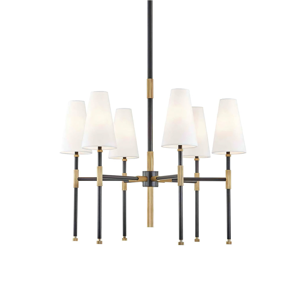 Front view of this Clérachic chandelier in black and brass, six tapered white linen shades on slim arms around a central rod.