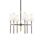 Front view of this Clérachic chandelier in black and brass, six tapered white linen shades on slim arms around a central rod.