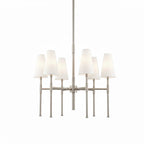 Nickel version of this Clérachic six-light chandelier, with six white linen shades on slim satin-nickel arms and a tall central rod.