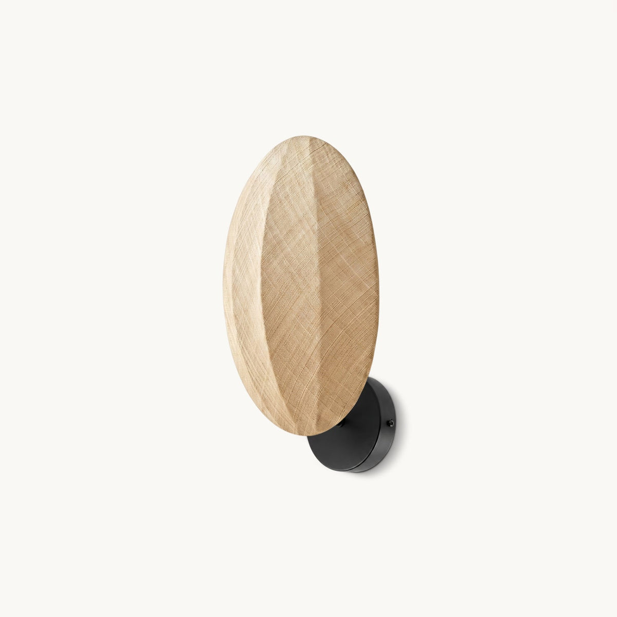 A Clérachic wall light on a plain white backdrop, an upright oval of woven linen with a centre ridge on a black round wall mount.
