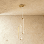Clérachic double brushed gold oval loop pendant, two linked LED rings glowing on clear cords from a gold canopy.