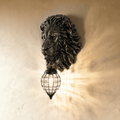 Clérachic black resin lion head wall light with a caged crystal lantern throwing a starburst of warm light across the wall.