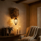 Clérachic gold lion head wall light with crystal lantern at dusk, warm light over a shelf of books, candles and a wool throw.