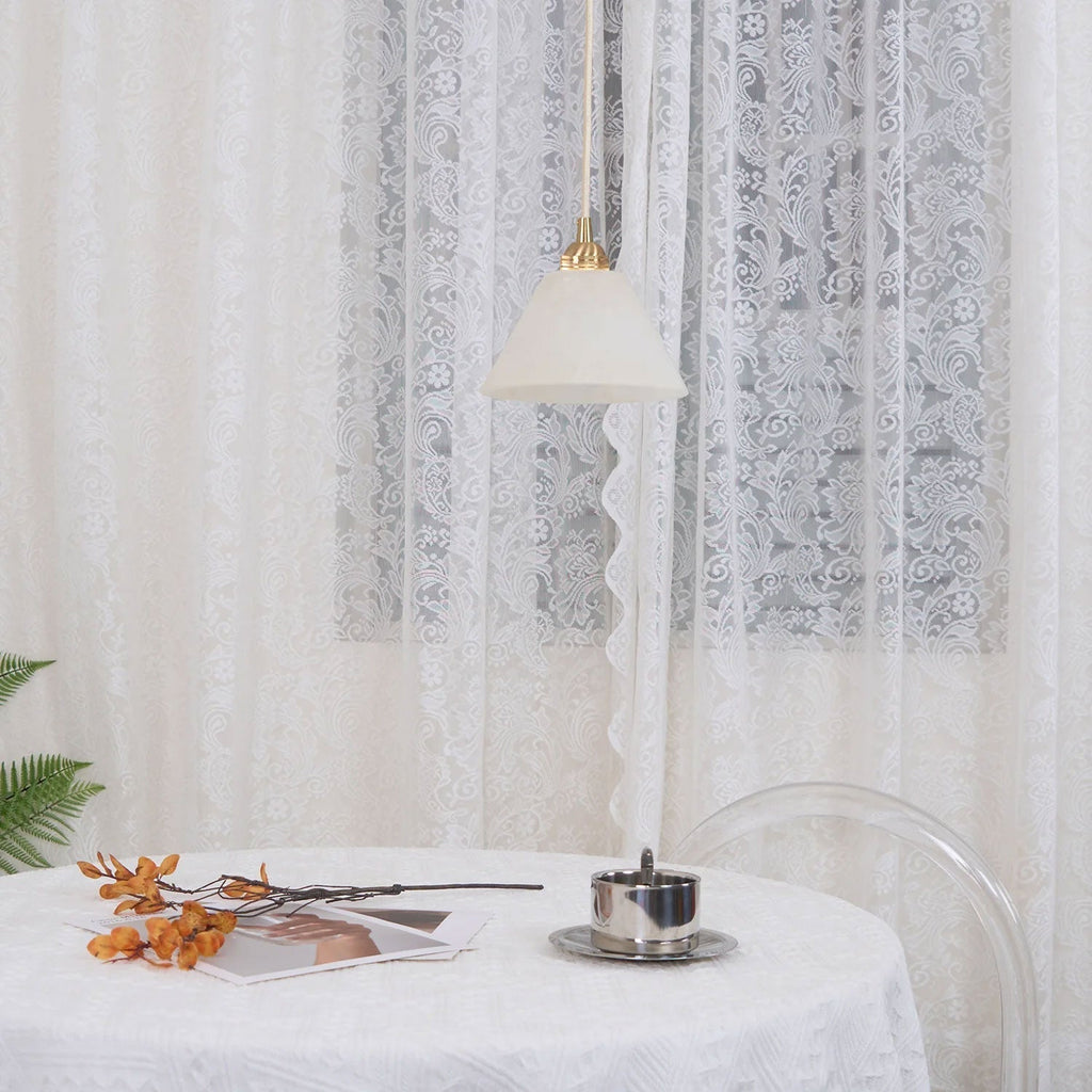 Clérachic pendant unlit in a soft white room, the pale cone hung against layered lace curtains.