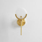 Clérachic alabaster sconce against white plaster, the stone disc, brass cradle and slender dropped stem shown in full.