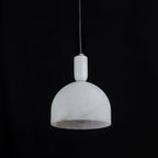 Unlit Clérachic Long-Drop Dome pendant light on black, the chalky alabaster shade cool and faintly grey-veined.