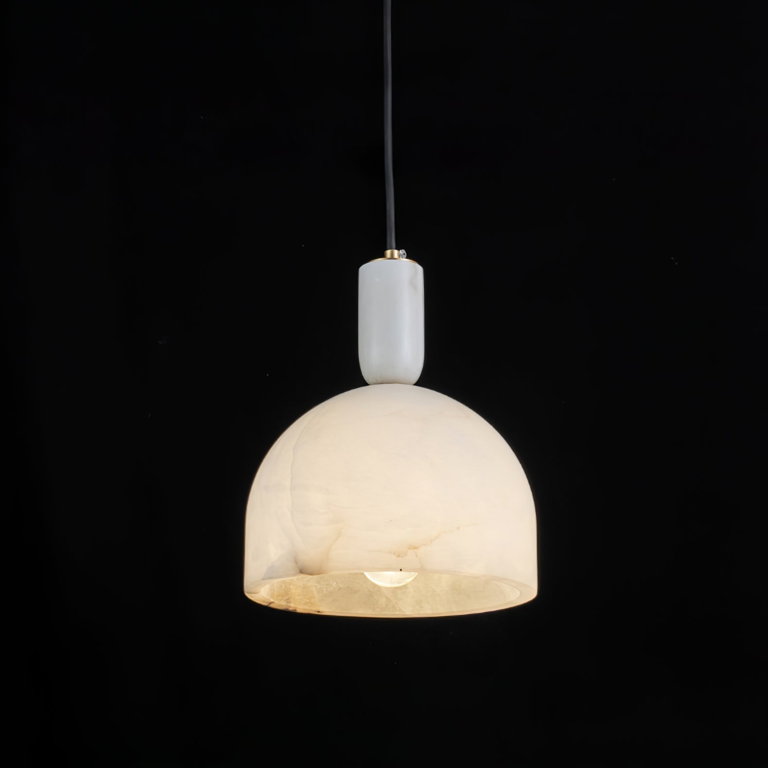 Clérachic Long-Drop Dome pendant light lit against black, the open underside pooling warm light around the bulb.