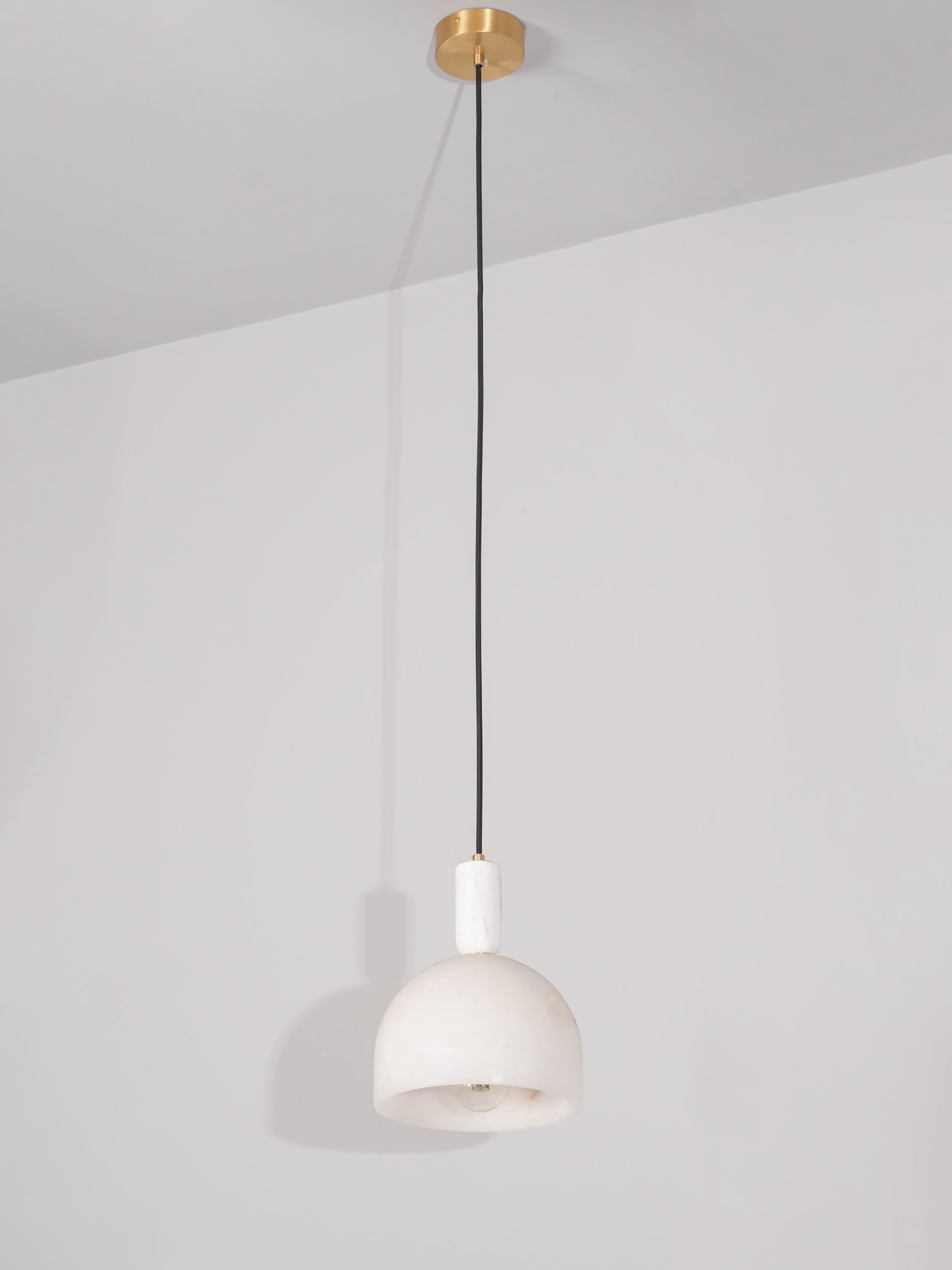 Full drop of the Clérachic Long-Drop Dome pendant light, brass ceiling canopy to shade down a long black cord.