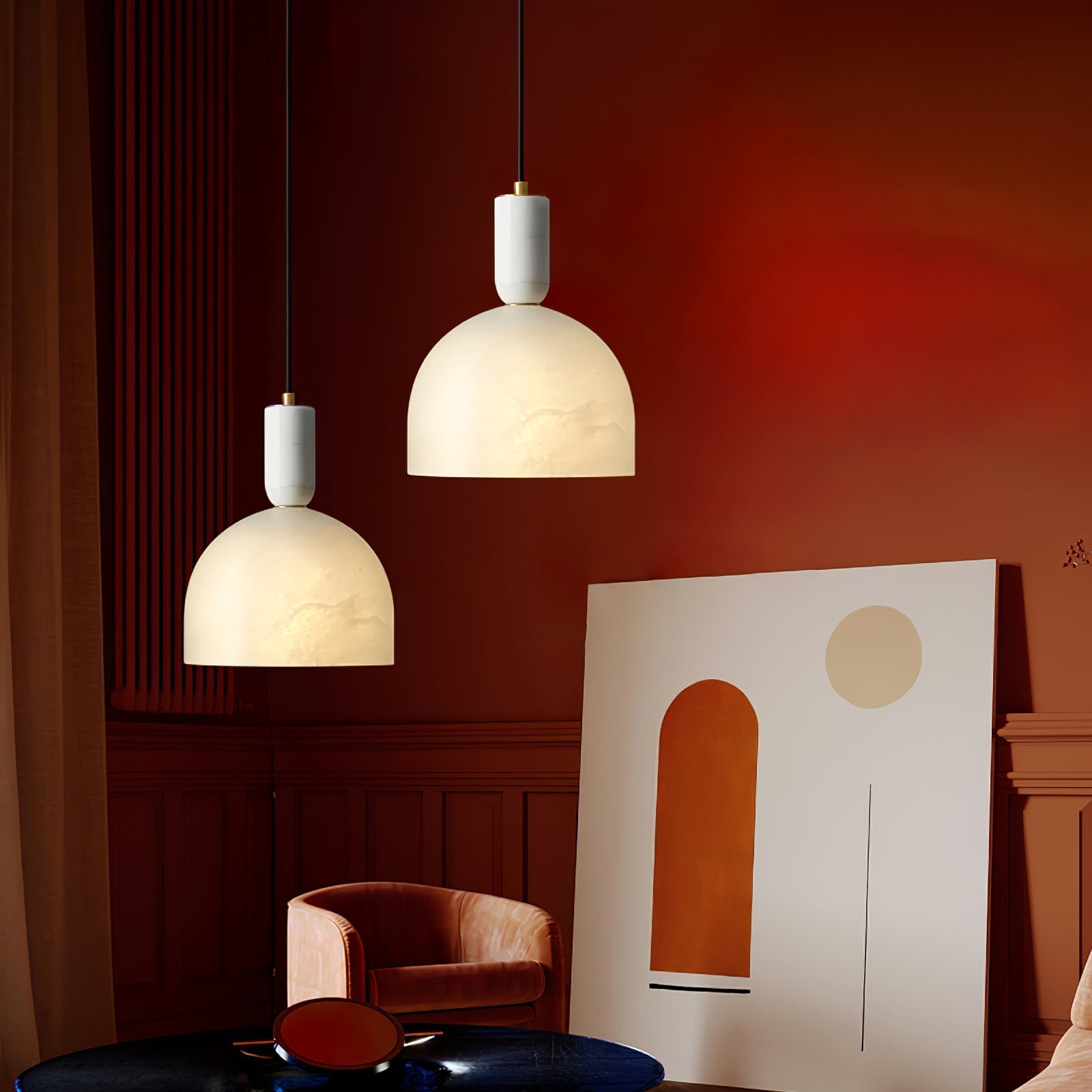 Two Clérachic Long-Drop Dome pendant lights at staggered heights in a deep red room with a leaning canvas below.
