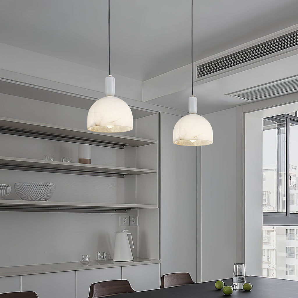 Two Clérachic Long-Drop Dome pendant lights lit over a table in a pale grey kitchen with open shelving.