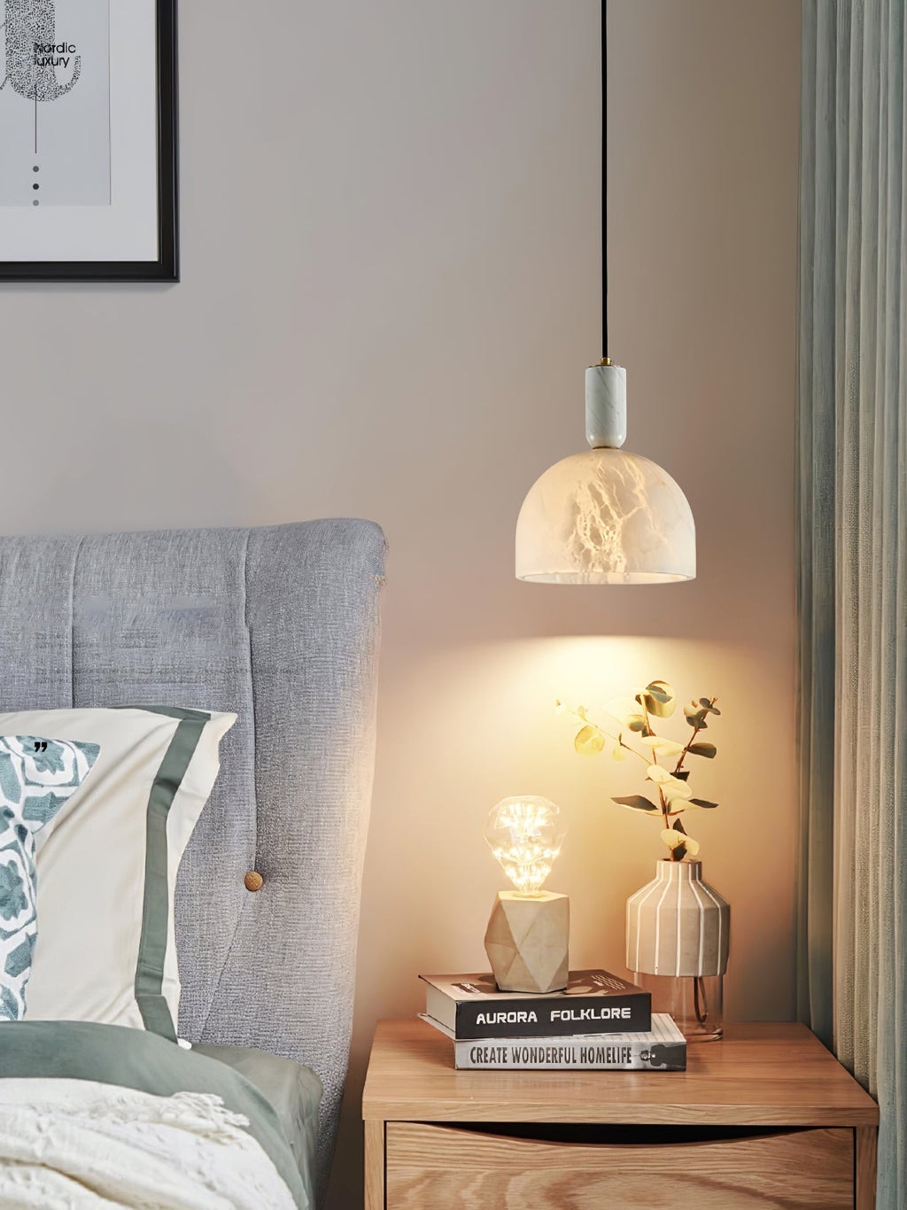 Clérachic Long-Drop Dome pendant light as bedside lighting, warm light falling over eucalyptus on a wood nightstand.