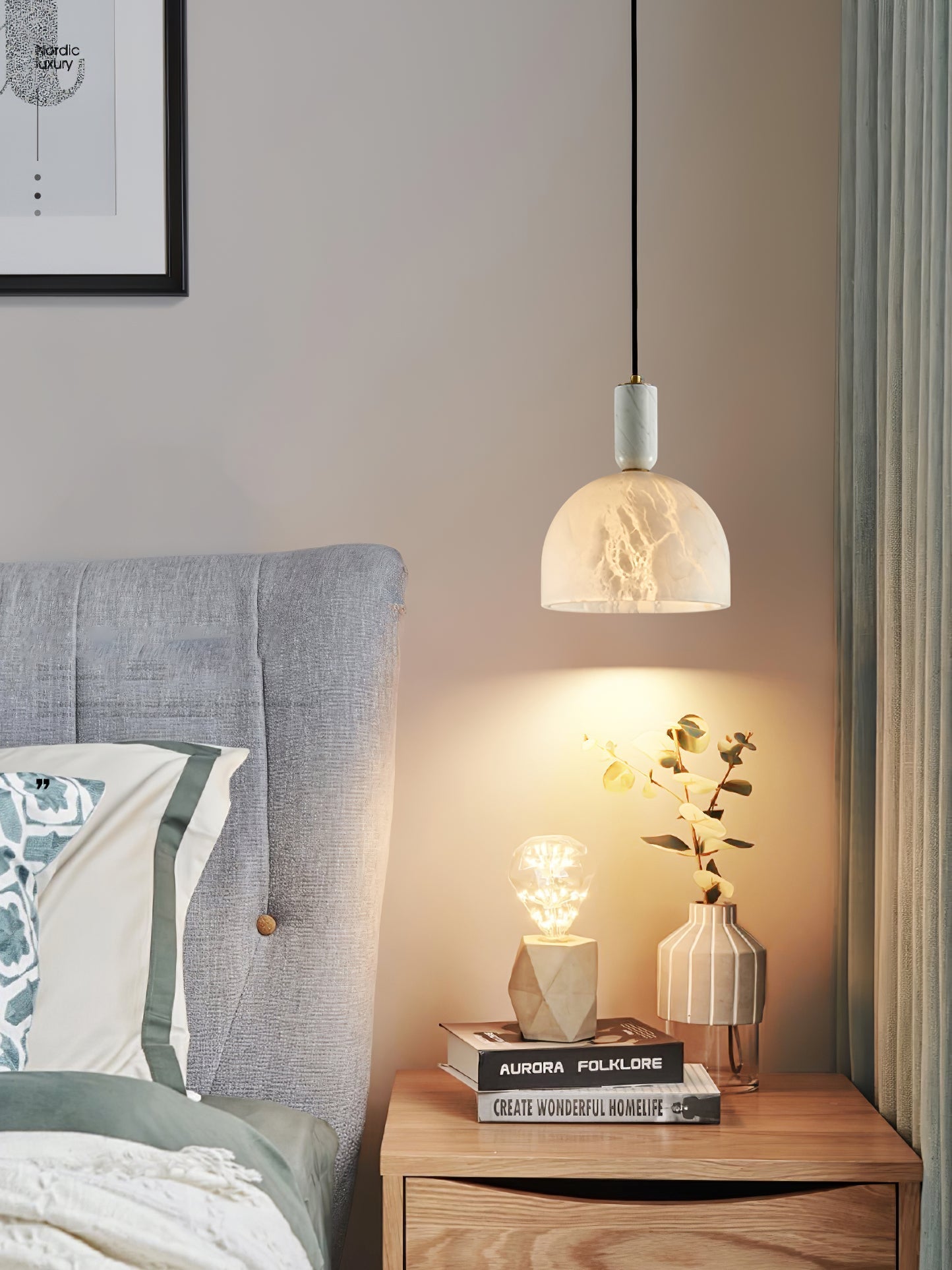 Clérachic Long-Drop Dome pendant light as bedside lighting, warm light falling over eucalyptus on a wood nightstand.