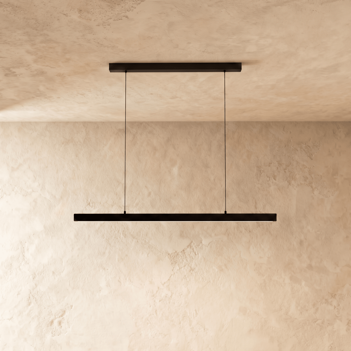 Clérachic black linear pendant bar hangs low from a plaster ceiling, framed by a warm limewash backdrop.