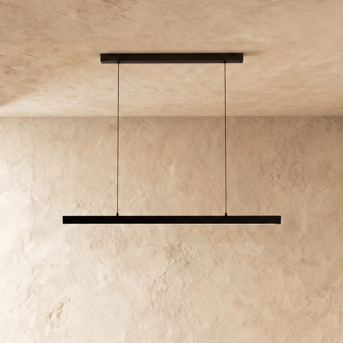 Clérachic black linear pendant, its slim bar catching the light, hangs against a warm plaster wall.