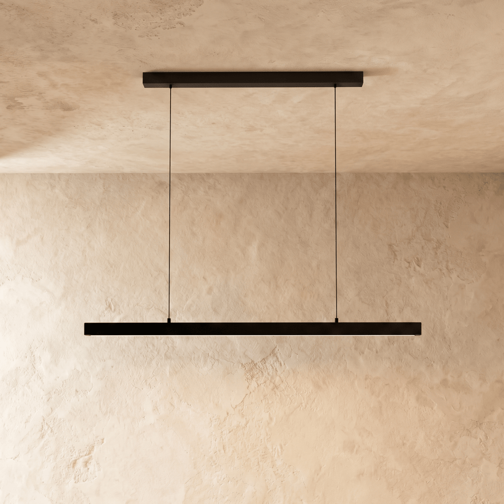Clérachic black linear pendant bar suspended from a plaster ceiling, shown against a limewash wall.