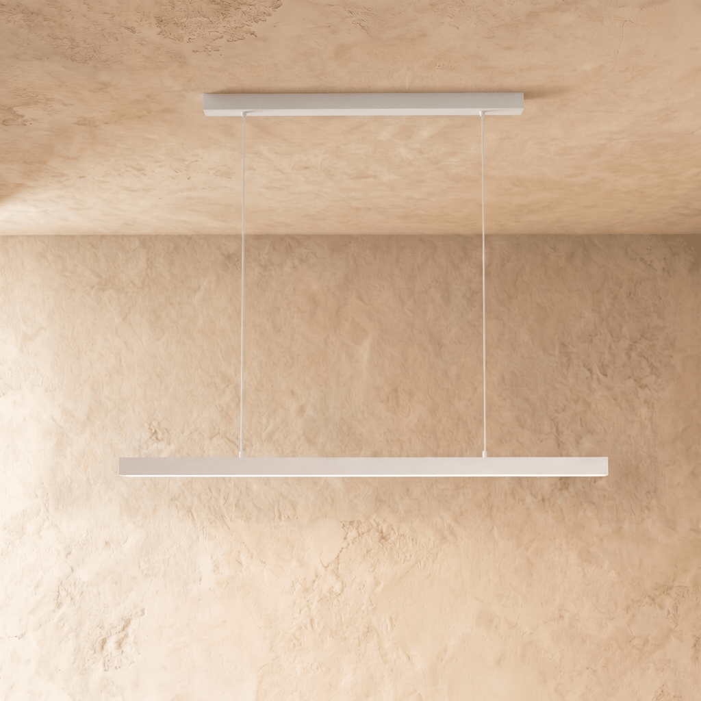 Clérachic white linear pendant bar suspended from a plaster ceiling, shown against a limewash wall.