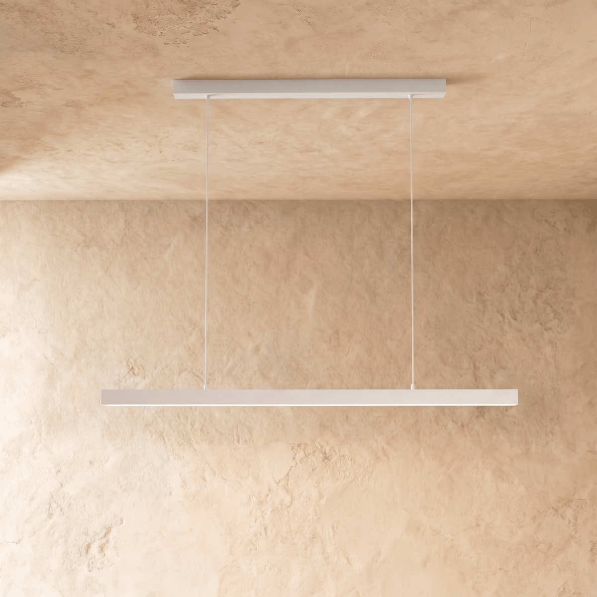 Clérachic white linear pendant bar suspended from a plaster ceiling, shown against a limewash wall.