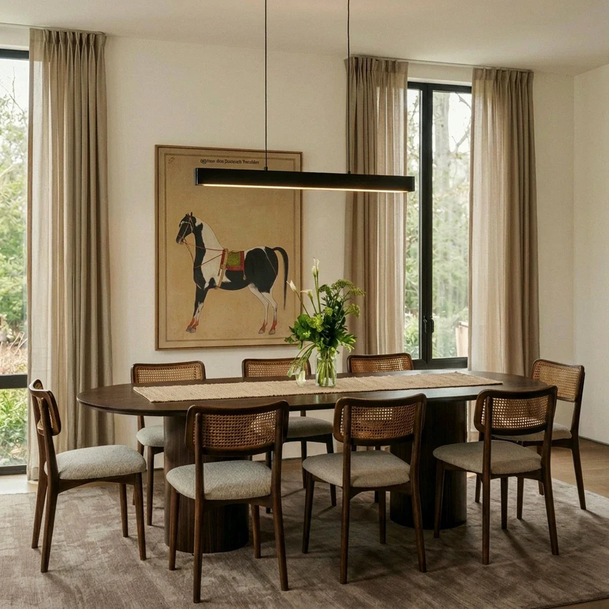 Clérachic black linear pendant lights a walnut dining table, warm curtains and an equestrian print behind.