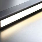 Clérachic pendant detail: warm light spilling from the diffuser along the edge of the matte-black bar.