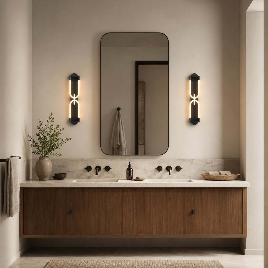 Two black Clérachic wall lights lit either side of a rounded mirror, above a floating walnut vanity with black taps.
