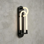 Black Clérachic wall light from an angle, its two nested glowing loops standing out from a long oval backplate.