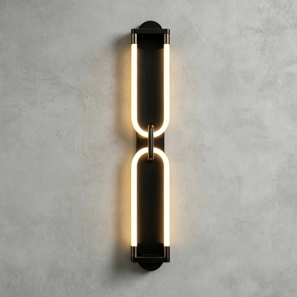 Black Clérachic wall light on a grey plaster wall, two stacked glowing loops joined at the middle by a small link.