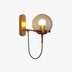 Product shot of the bronze Clérachic wall sconce on a white background, its glass globe lit and cord looped beneath the arm.