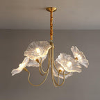 The 6-light clear glass Clérachic Lotus Blossom Chandelier, six ruffled shades fanned out and lit against a grey wall.