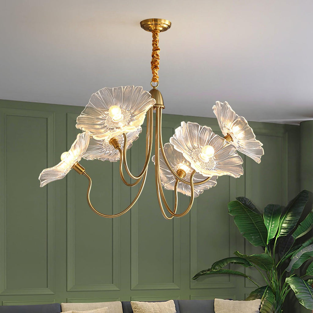 The Clérachic Lotus Blossom Chandelier's clear glass shades lit above a console in a green-panelled living room with a plant.