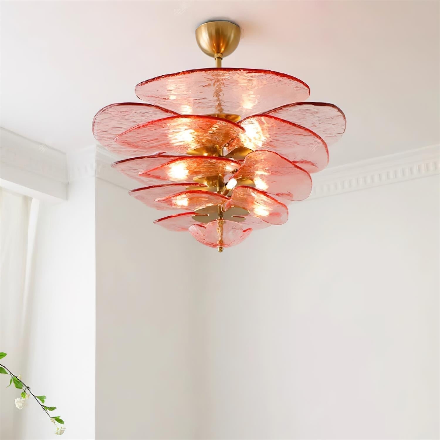 Pink Clérachic lotus leaf chandelier lit on a white ceiling, the glow spreading through five stacked leaf tiers.